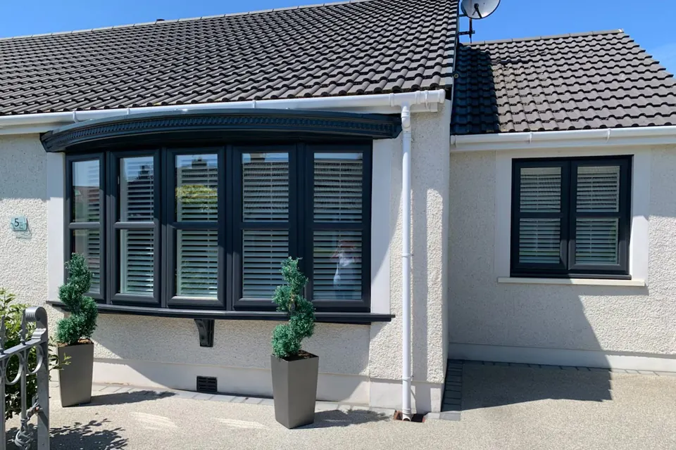 Anthracite grey bay window on a rendered bungalow