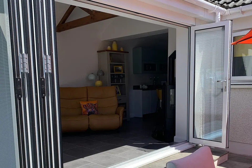 Bi-fold doors folded open from inside a garden room