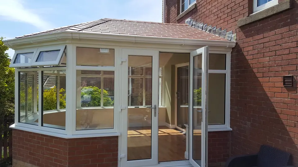 Conservatory with a tiled roof and white frames