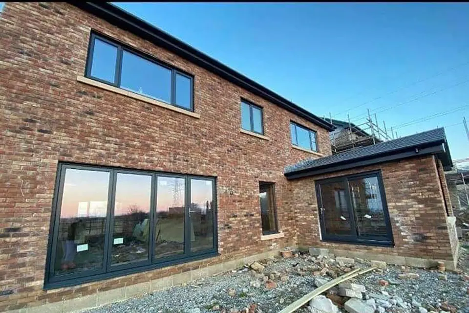 Rear of a new build with anthracite grey triple glazed windows and French doors